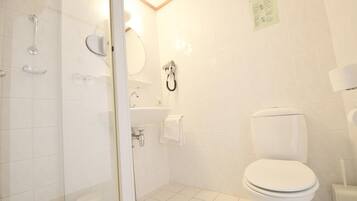 Un baño con inodoro, lavamanos y ducha.