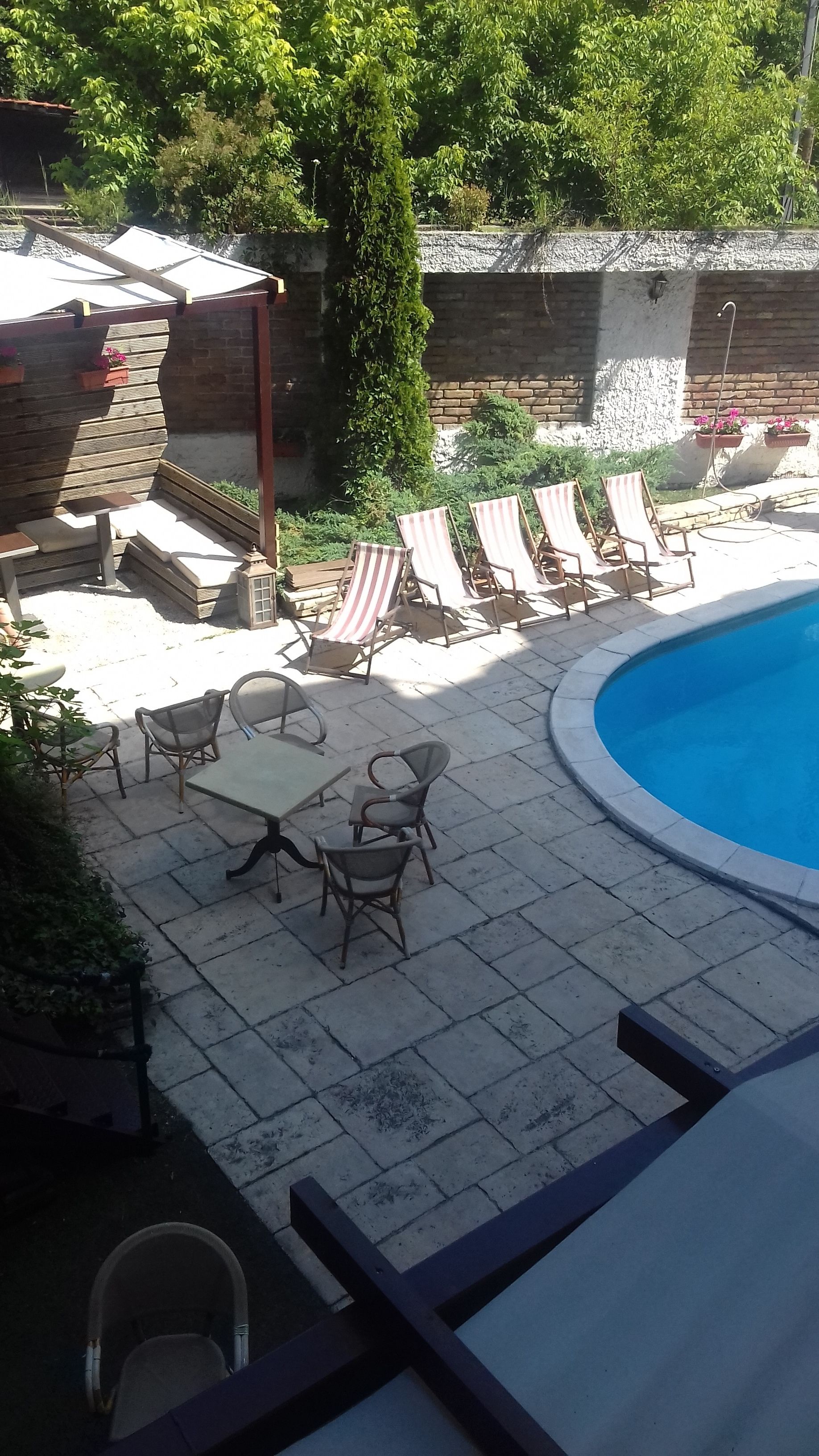 Una piscina al aire libre, sombrillas, sillones reclinables de piscina