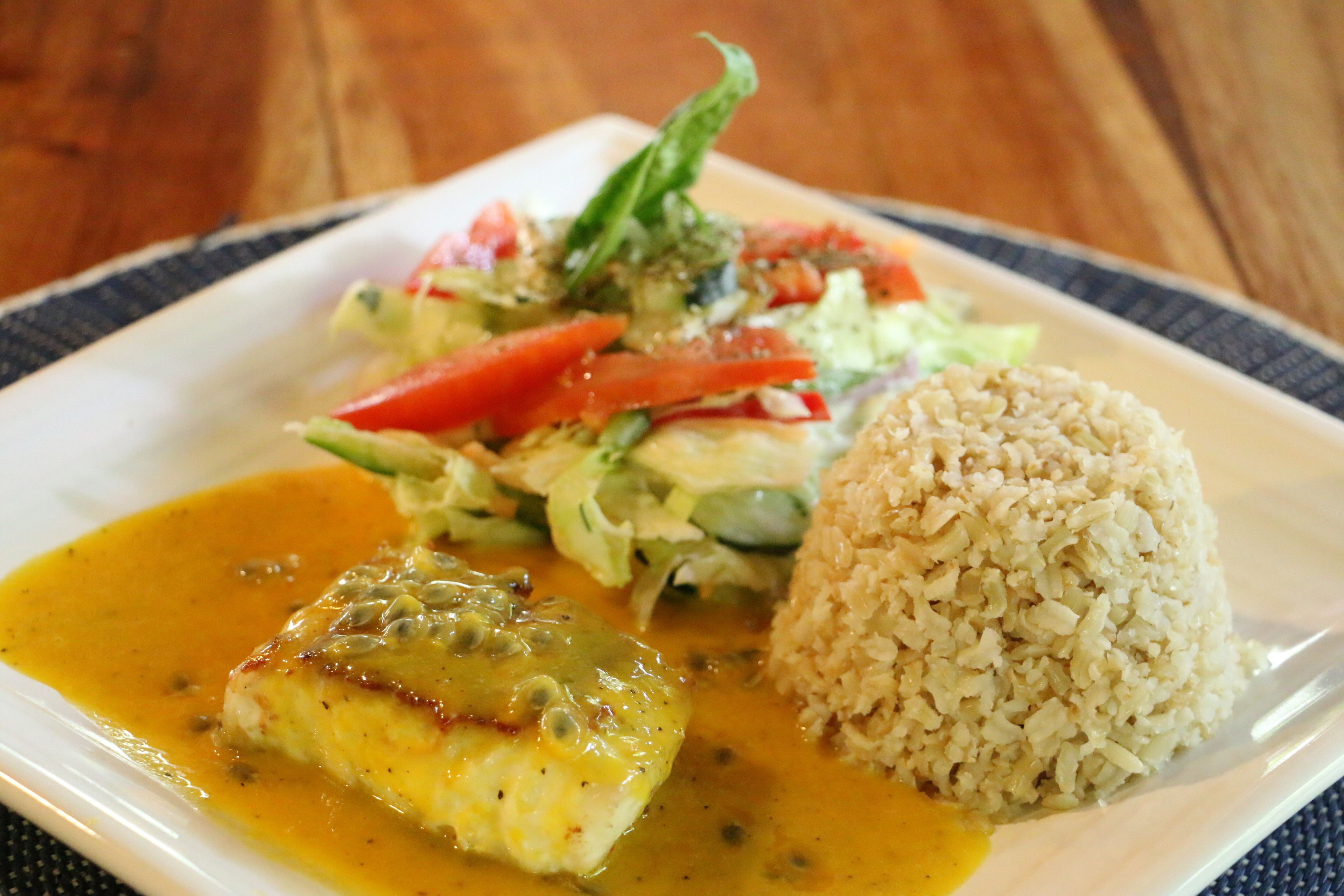 A plate with rice, a piece of fish, and a salad.