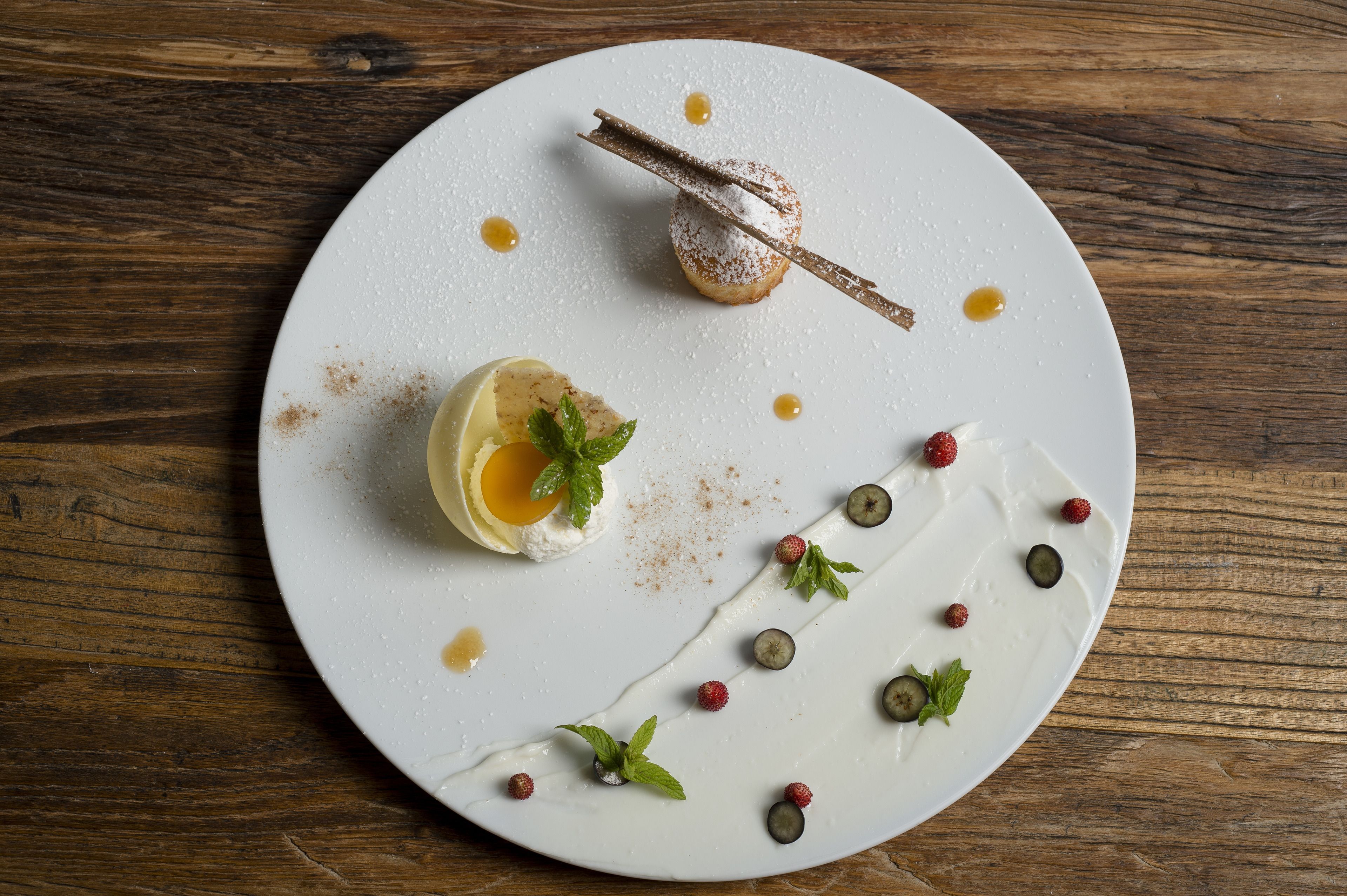Ein weißer Teller mit Dessert auf einem Holztisch.
