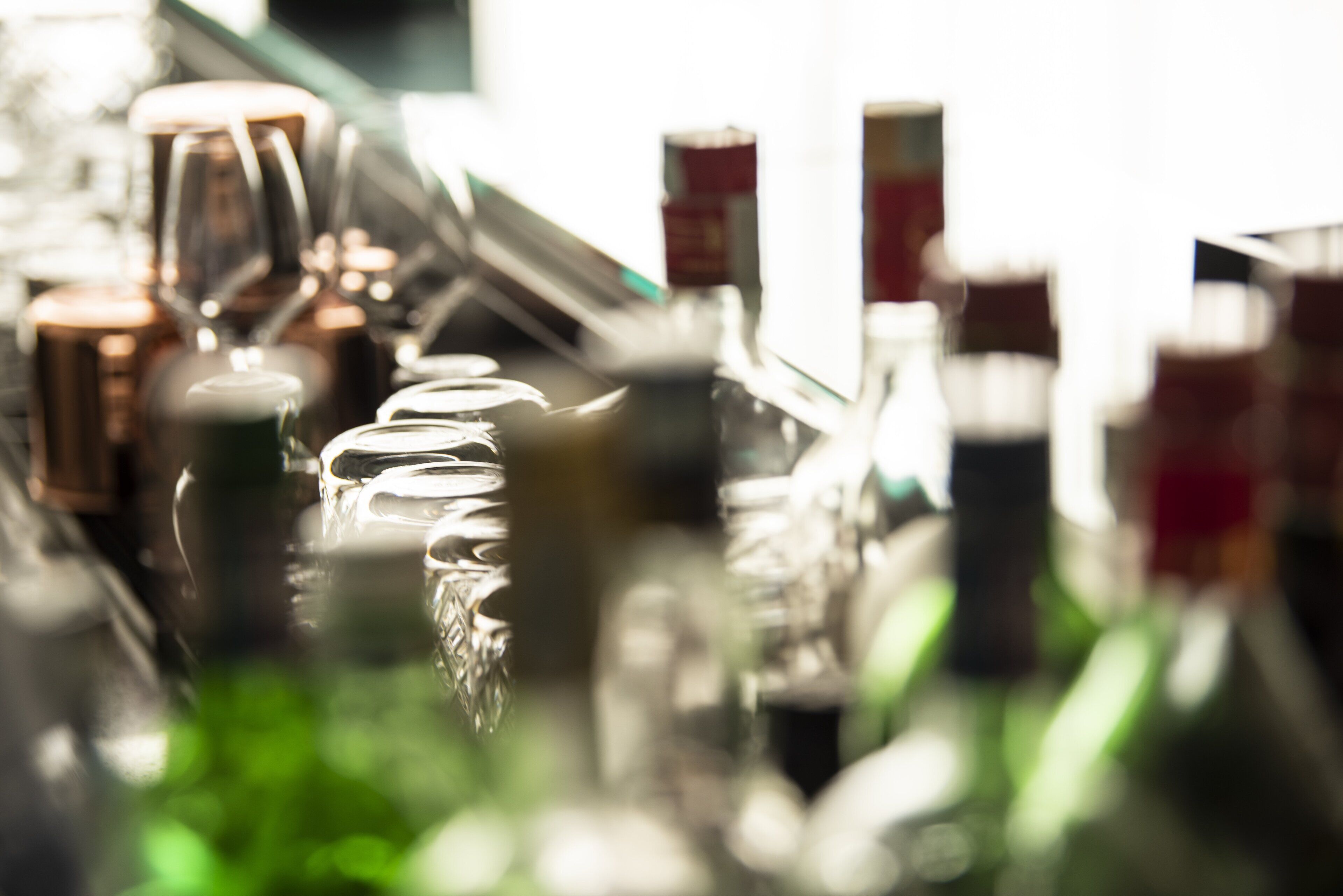 Un espace bar avec différentes bouteilles et différents verres.