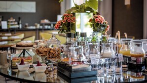 A buffet table with various food items, including desserts and beverages, and a decorative plant centerpiece. - Villa Neri Resort & Spa (Linguaglossa)