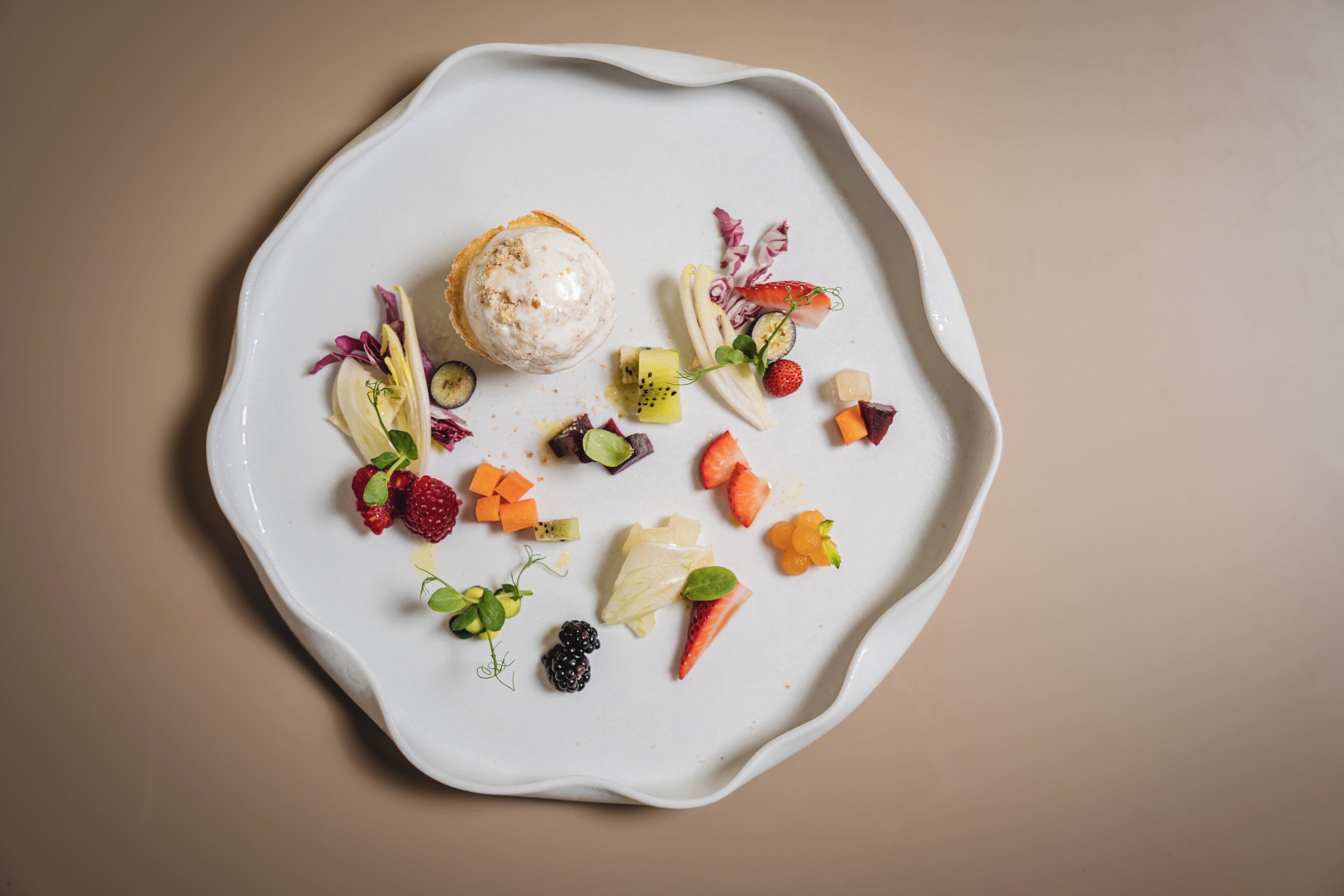 Une assiette blanche contenant un dessert et divers fruits.