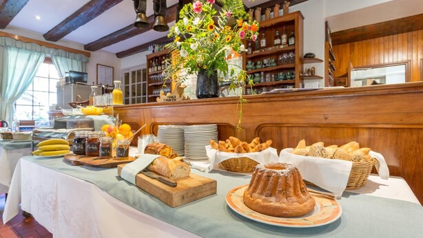 Een buffetopstelling met diverse broden, gebakjes en een fruitpresentatie.
