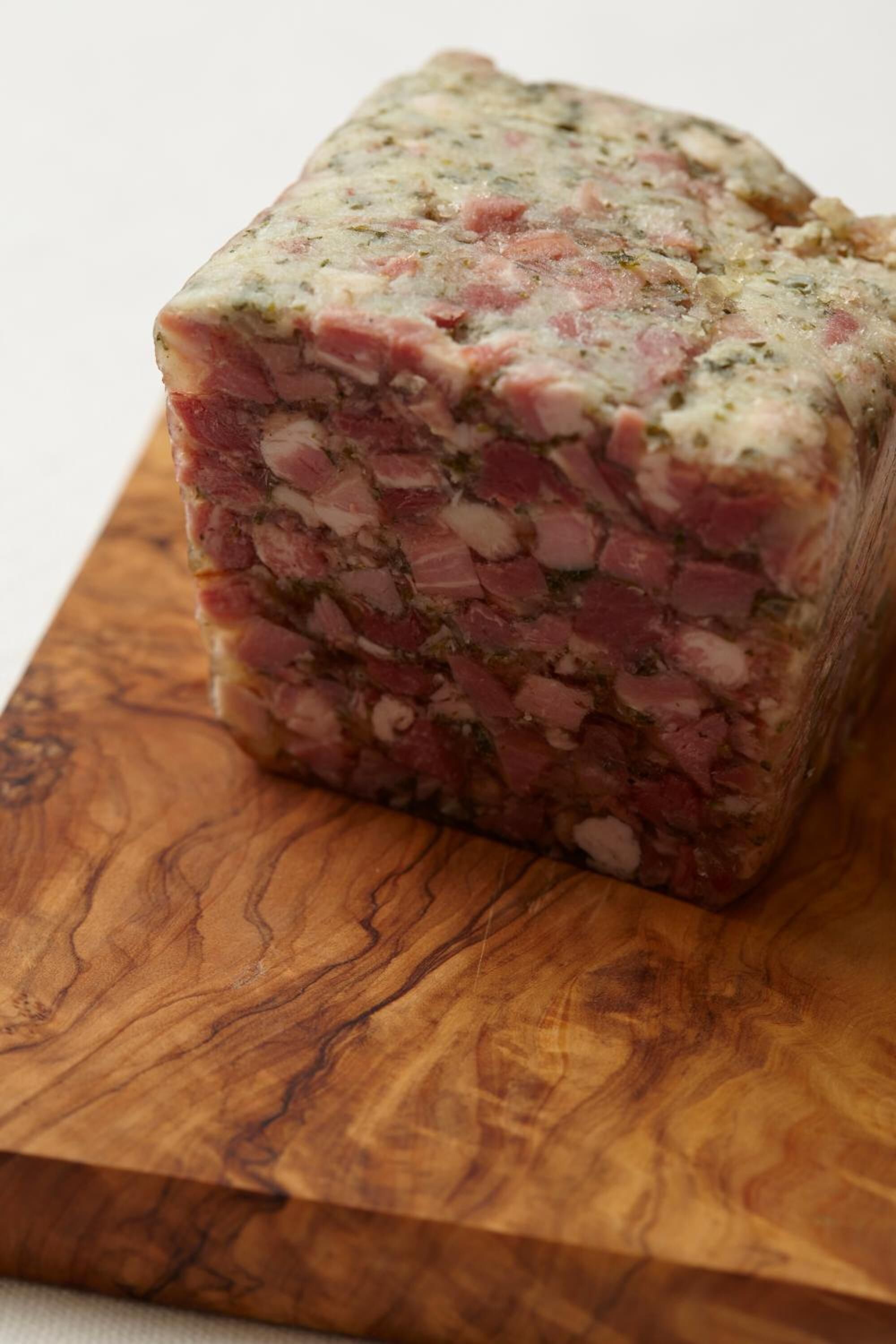 Une portion de pain de viande sur une planche à découper en bois.