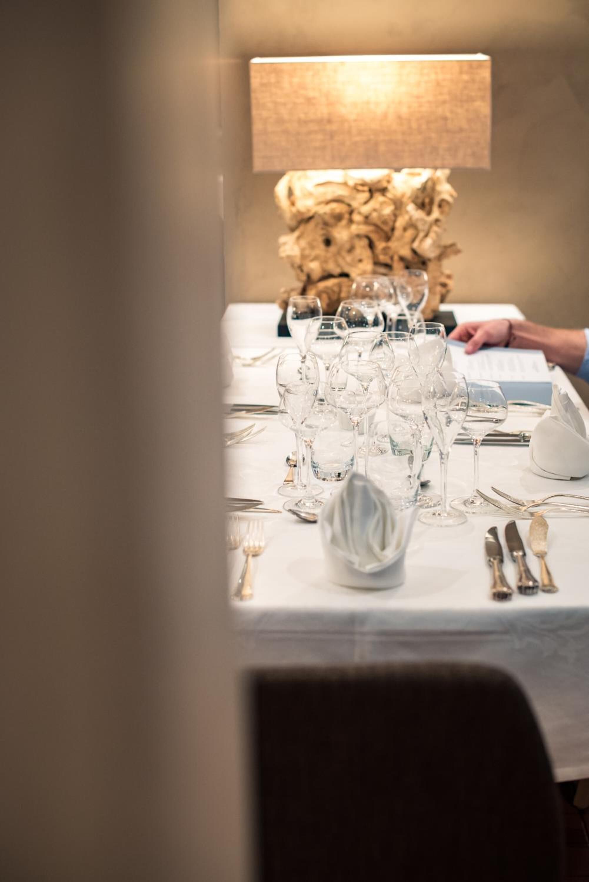 A table set for a formal dining occasion with multiple wine glasses, water glasses, and cutlery.