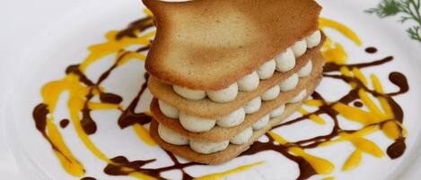 A dessert with layers of cookies and cream, drizzled with chocolate and caramel sauce.