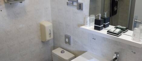 A modern bathroom with a toilet, sink, and shower.