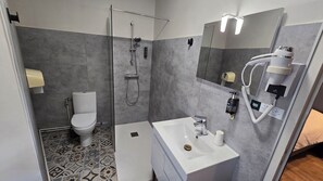 Un baño moderno con inodoro, ducha y lavamanos.