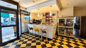 A bar area with stools, a counter, and a refrigerator stocked with beverages.