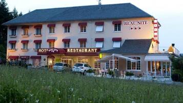 A hotel with a restaurant, outdoor seating, and a sign indicating it is a 3-star establishment.