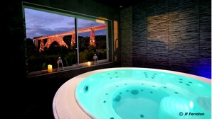 A hot tub with a view of the Eiffel Tower at dusk. - Hôtel Beau Site (Val-d'Arcomie)