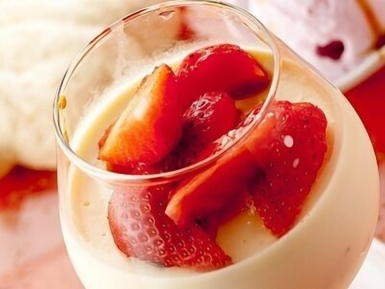 A dessert with strawberries in a glass.