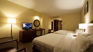 A hotel room with a bed, a television, a desk, and a chair. - Gaya Centre Hotel (Kota Kinabalu)