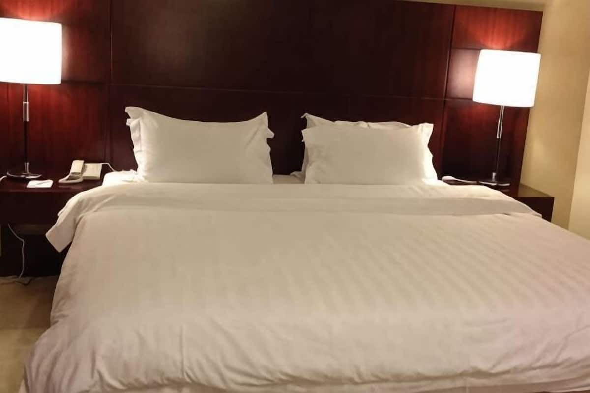 Habitació d'hotel amb un llit gran, dues làmpades de nit, un telèfon i una taula de nit.
