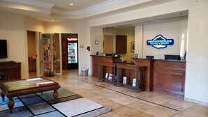 A reception area with a counter, a Coca-Cola refrigerator, a television, and a seating area with a table and chairs. - Port of Kimberling Marina & Resort (Kimberling City)