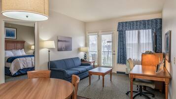 Una habitación de hotel con cama, sofá, mesa de comedor y escritorio.