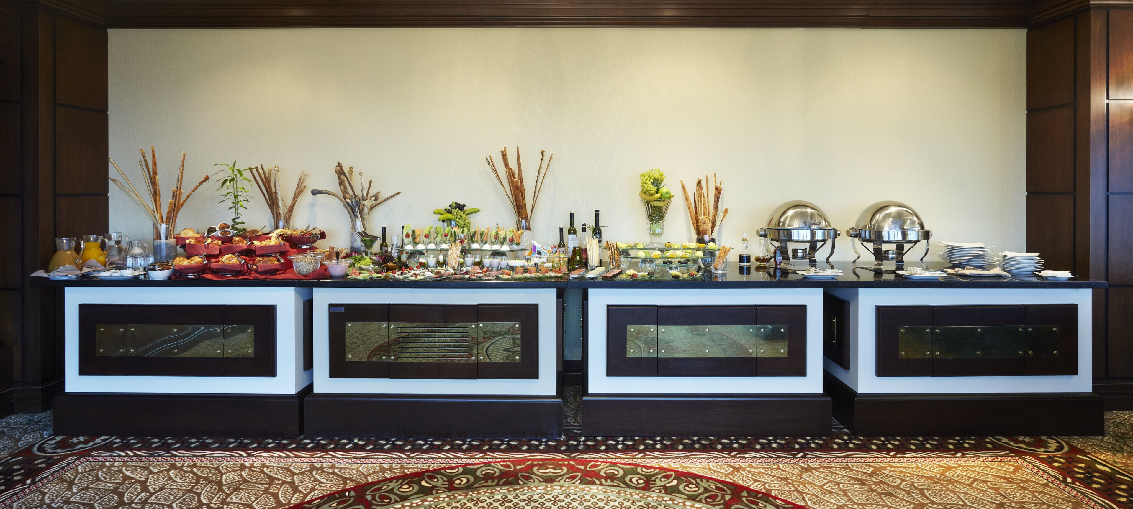 Un buffet composé de plusieurs présentoirs de nourriture et agrémenté d’éléments décoratifs.
