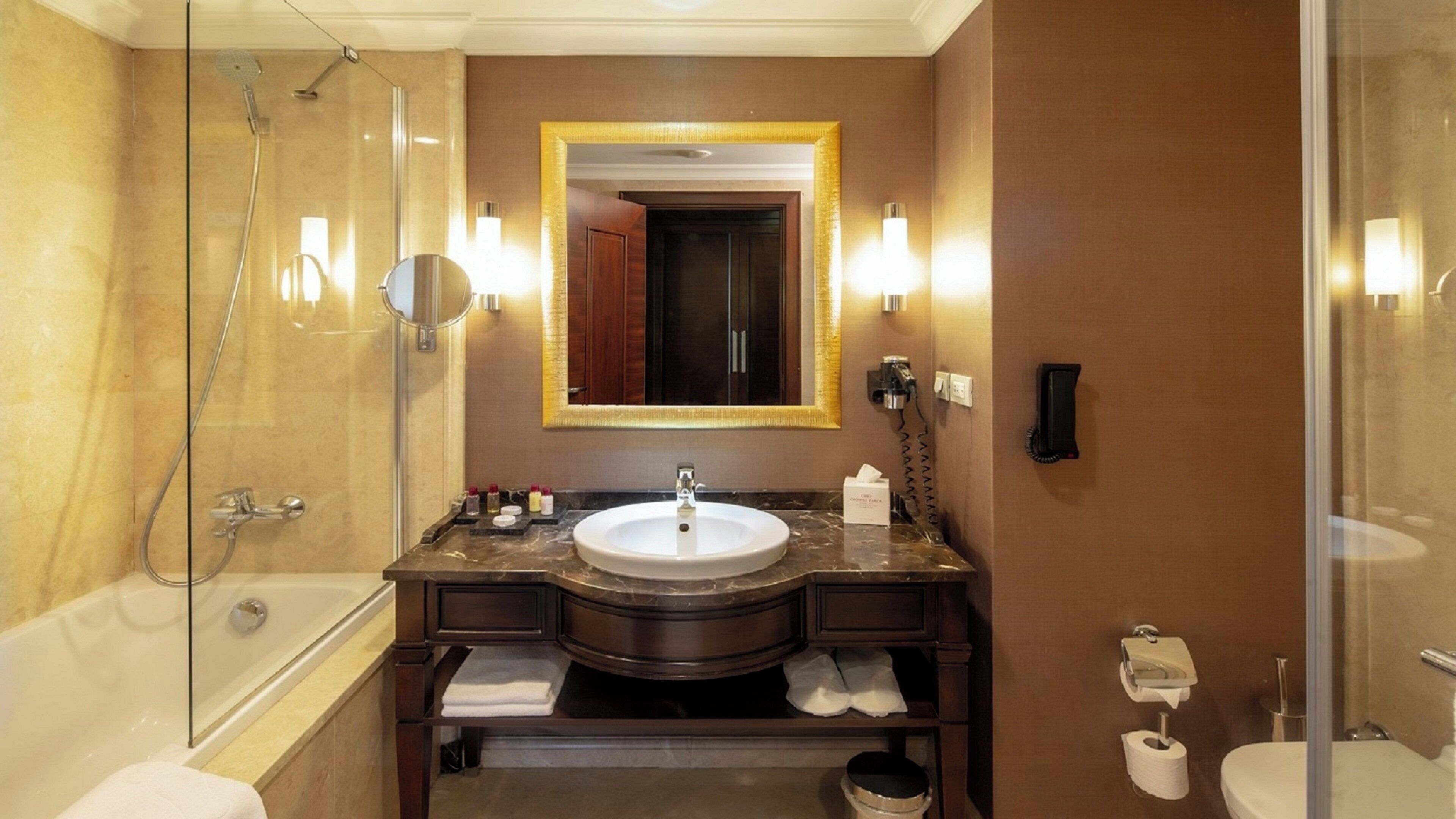 Un baño con bañera, lavamanos, espejo y retrete.