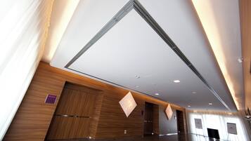 A spacious lobby with a high ceiling, wooden paneling, and a large, open area.