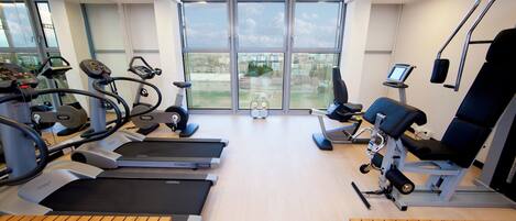 A gym with treadmills, exercise bikes, and a rowing machine.