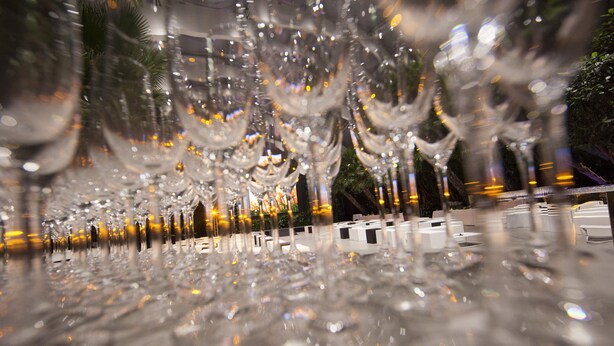 A row of empty wine glasses on a reflective surface.