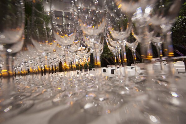 Une rangée de verres à vin vides sur une surface réfléchissante.