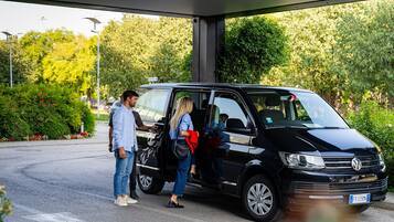 A black Volkswagen van parked at a gas station with a person exiting the vehicle.