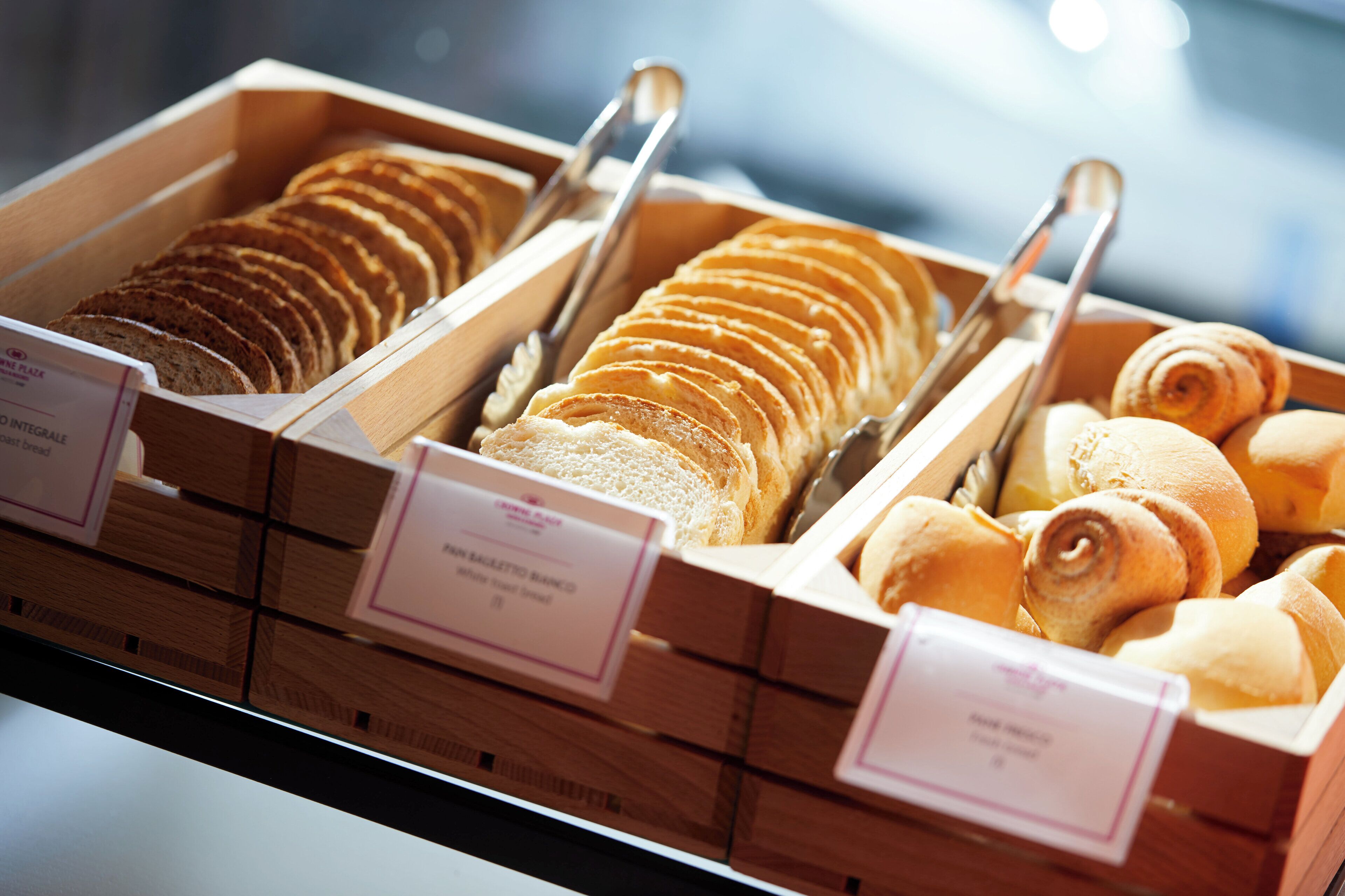 A bakery display with various types of bread and pastries.