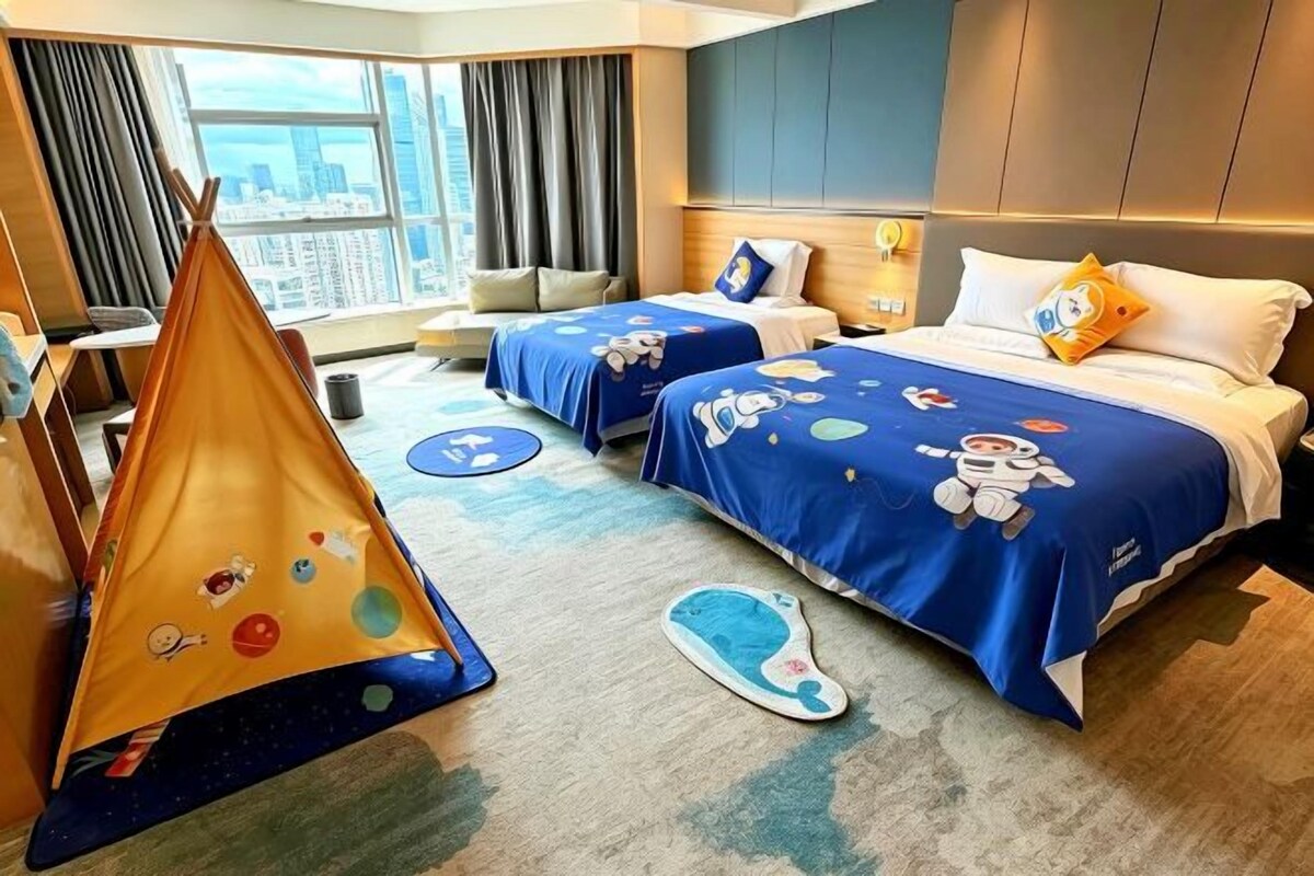 Ein Hotelzimmer mit zwei Betten, einem Zelt und Blick auf die Stadt.