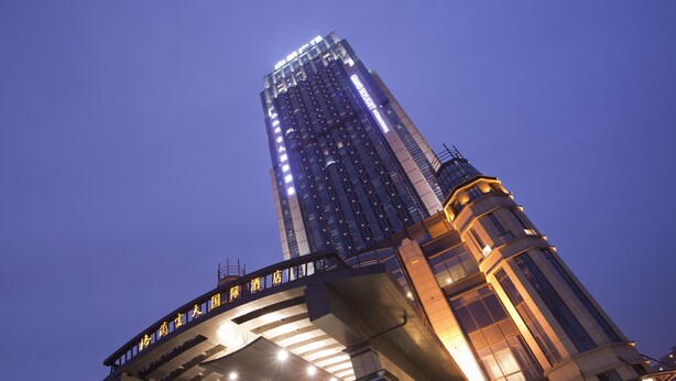 A high-rise building with illuminated signage and a modern architectural design. - Grand Skylight International Hotel Nanchang (Nanchang)