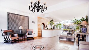 A spacious lobby with a reception desk, seating area, and decorative plants. - Hotel Suites Mar Elena (Puerto Vallarta)