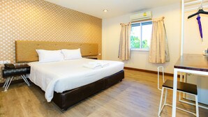 A hotel room with a large bed, a desk, and a chair. - Parasol Inn Chiang Mai Old City (Chiang Mai)