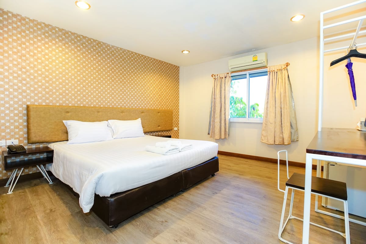 Ein Hotelzimmer mit einem großen Bett, einem Schreibtisch und einem Stuhl.