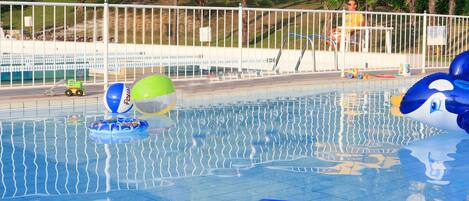 A swimming pool with inflatable toys and a toy car.