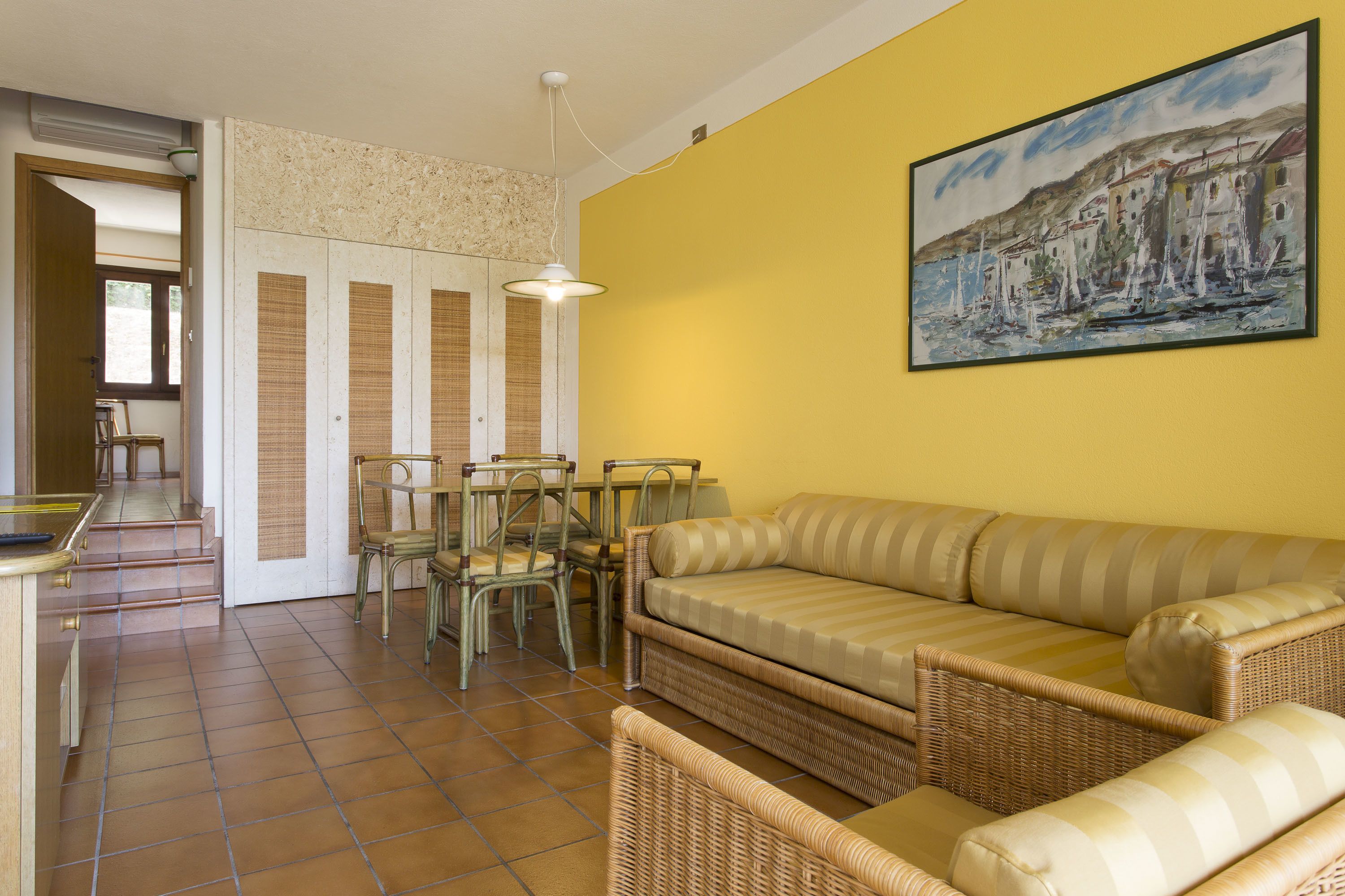 A living room with a sofa, chairs, and a dining table.