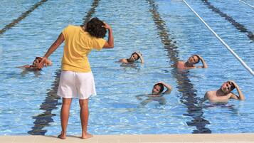En swimmingpool med flere baner, hvor folk svømmer.