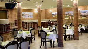 A restaurant with brick walls, white tables, and chairs. - Dobosz (Police)