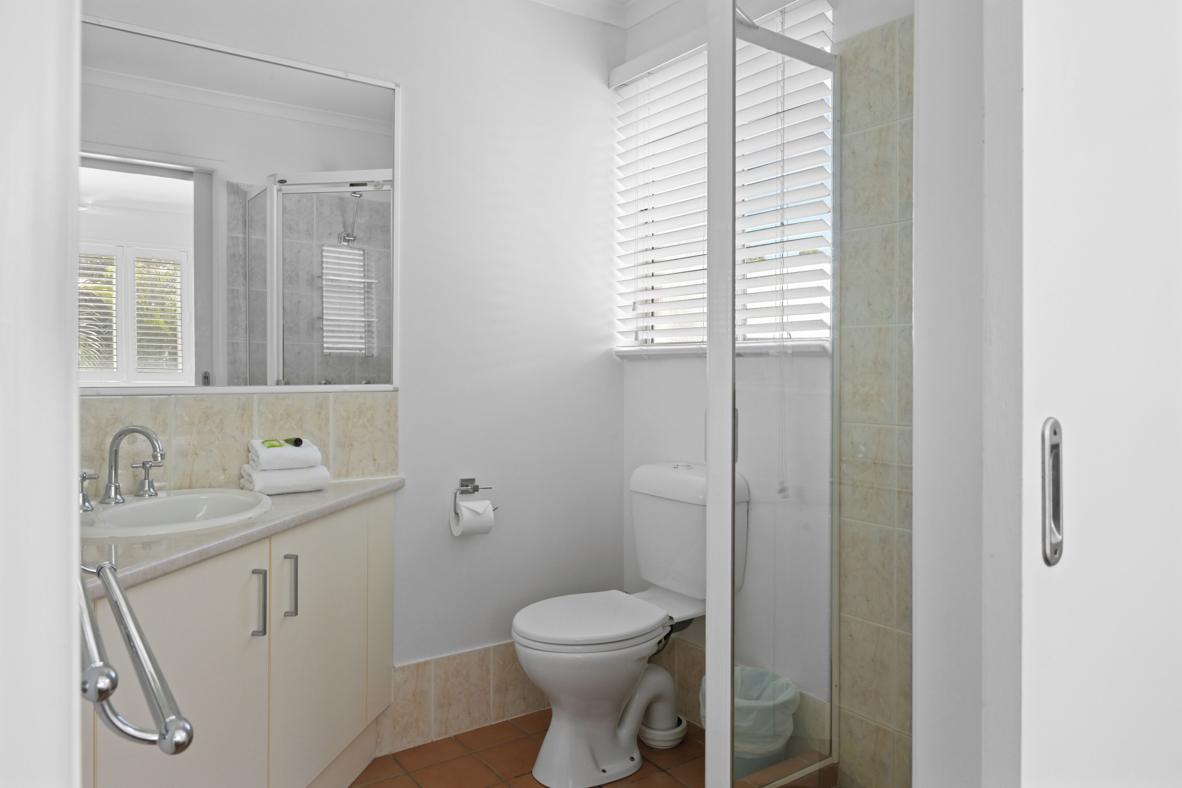 Ein Badezimmer mit Toilette, Waschbecken und Duschbereich.
