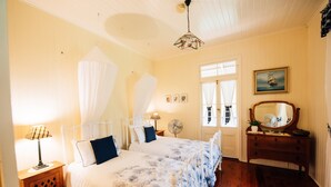A bedroom with two beds, a bedside table with a lamp, a dresser, a mirror, and a window with curtains. - Mt Barney Lodge Country Retreat (Mount Barney)