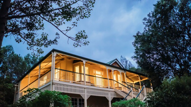 A two-story house with a balcony, surrounded by trees. - Mt Barney Lodge Country Retreat (Mount Barney)