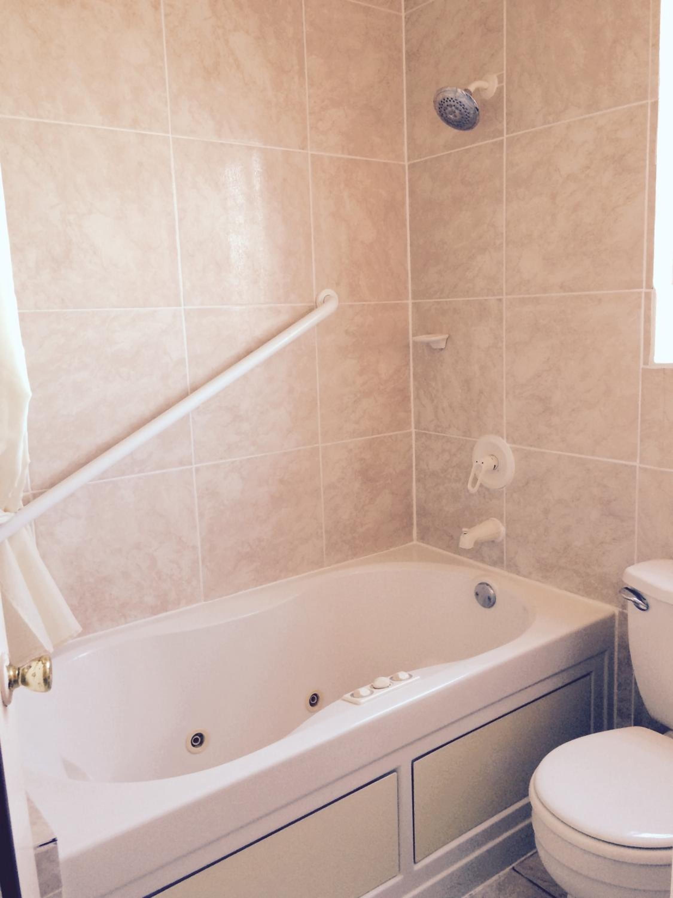 A bathroom with a bathtub, toilet, and shower.
