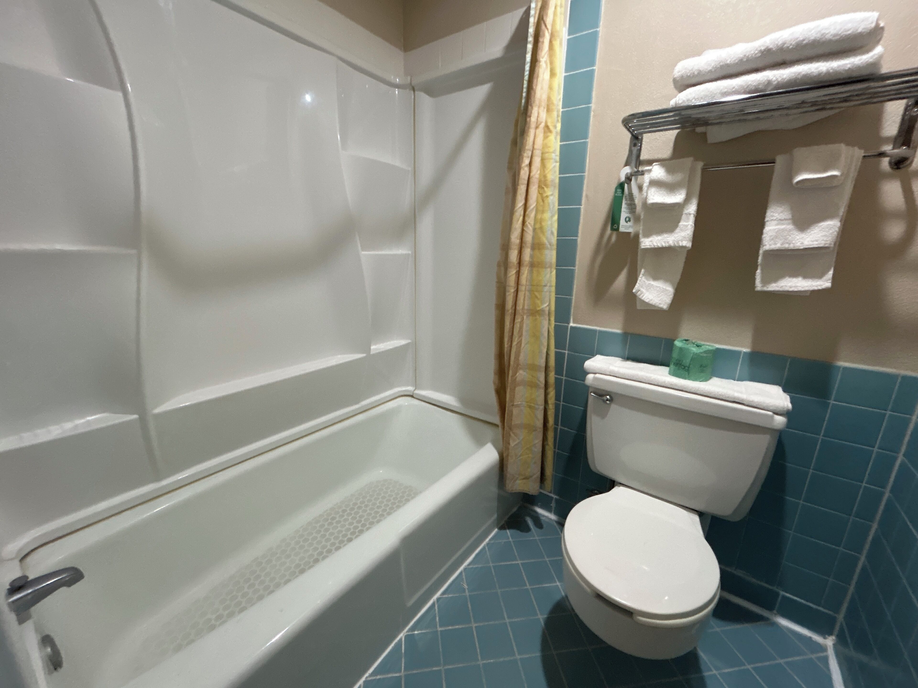 Ein Badezimmer mit Badewanne, Toilette und Handtuchhalter.