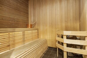 Una sauna de madera con bancos y un separador de madera.