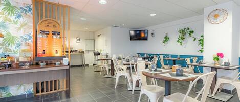 Un restaurant avec un comptoir, un espace pour s’asseoir et un téléviseur fixé au mur.
