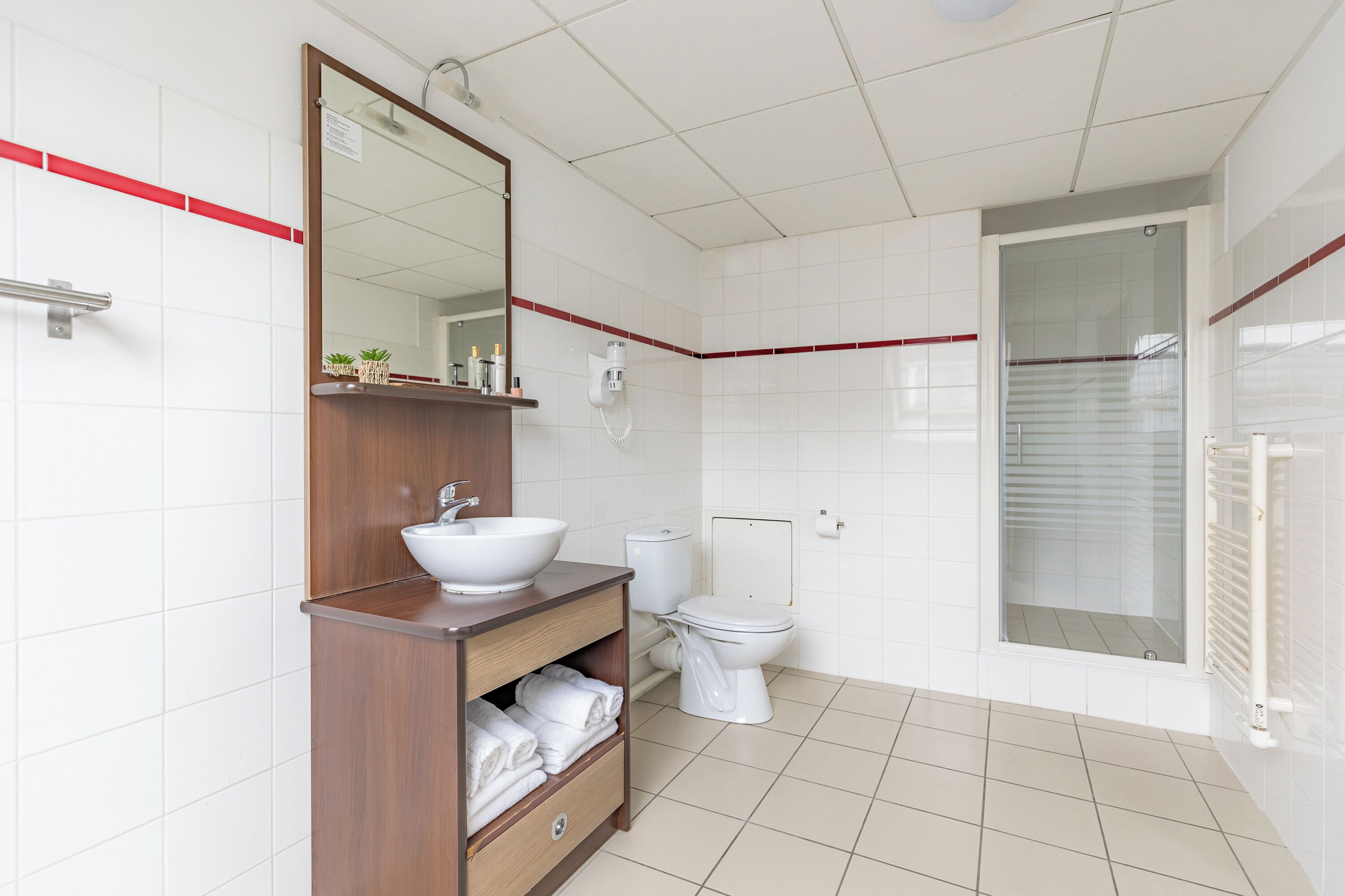 Superior appartement | Badkamer | Een douche, een haardroger, handdoeken, zeep