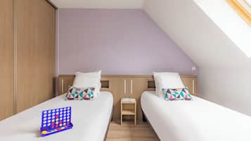 Cozy loft-style room with two single beds, a nightstand, and a wardrobe.