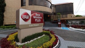 Placa de um hotel Best Western PLUS com um edifício moderno ao fundo.