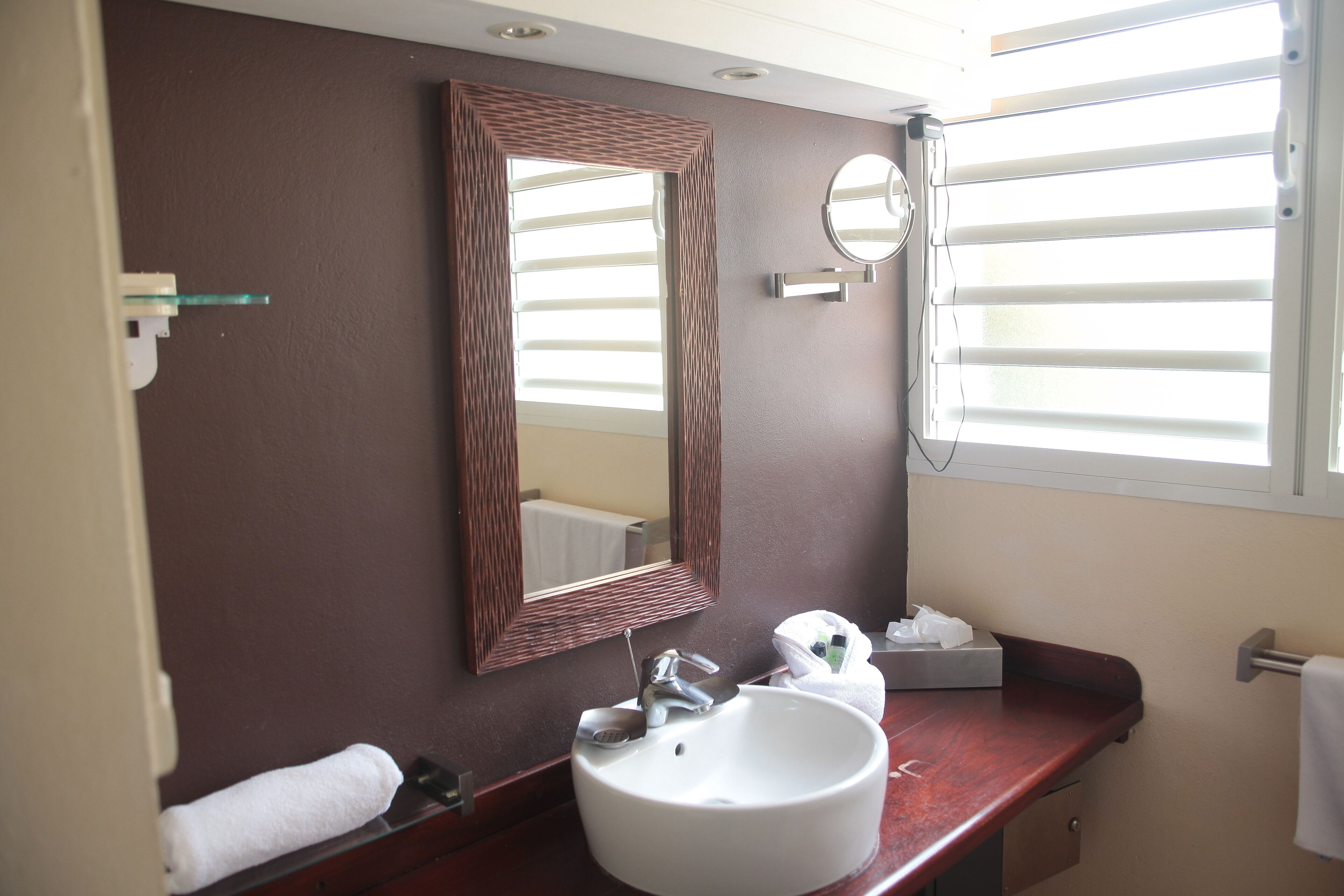 Une salle de bain avec un lavabo blanc, un miroir et un porte-serviettes.