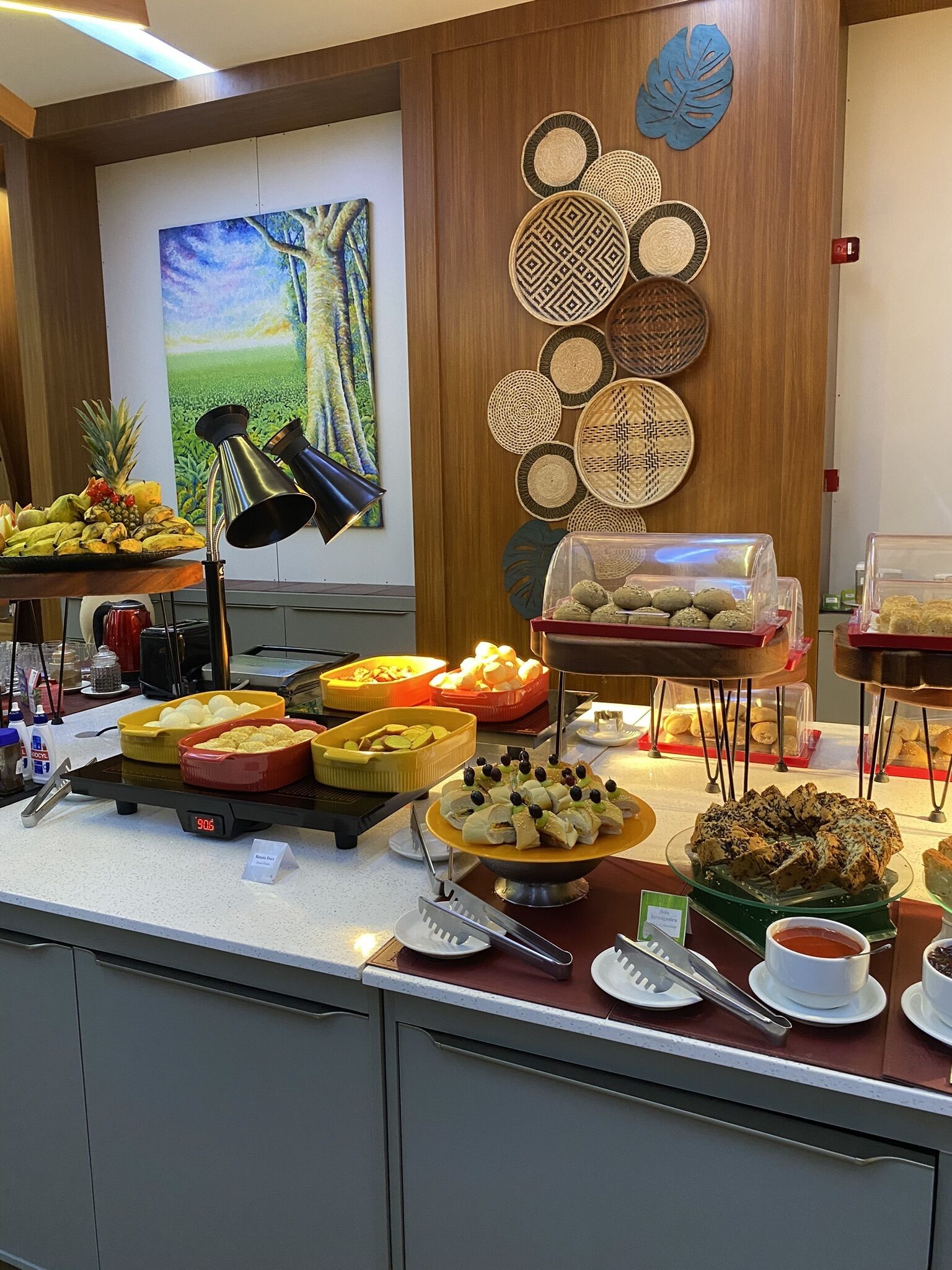 A buffet setup with various food items and a clock displaying 9:06.